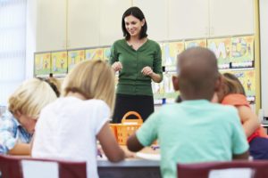 A teacher talks to a group of young students